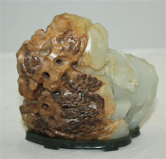 A Chinese pale celadon and russet jade boulder carving, height 10cm